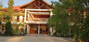 a building with a balcony on the side of it at Hôtel La Belle Etoile in Labuan Bajo