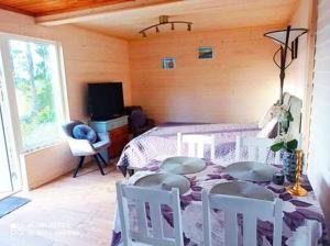 Schlafzimmer mit einem Bett, einem Tisch und Stühlen in der Unterkunft Lila Stuga in Väja