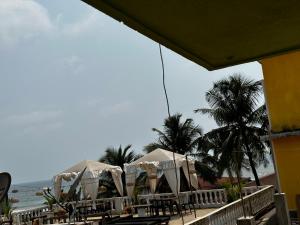 a beach with tables and umbrellas and the ocean at Seaway inn guesthouse in Baga