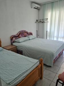 a bedroom with two beds and a window at Demir Apartmani in Donji Štoj