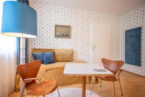 a living room with a couch and a table and chairs at Villa Gabriela in Pörtschach am Wörthersee