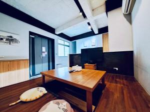 a large room with a wooden table in a room at 小城門 親子寵物包棟民宿 City Door Family and Pet-Friendly Entire Homes in Tainan