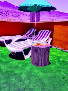 a group of chairs and a table with an umbrella at THE HAPPINESS PENTHOUSE Dream Holiday at 100m Beach! in Candelaria