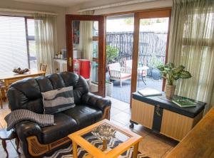 a living room with a leather couch and a table at Stay @ Honeytree in Edenvale