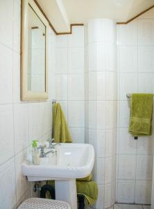 La salle de bains blanche est pourvue d'un lavabo et d'un miroir. dans l'établissement Stay @ Honeytree, à Edenvale