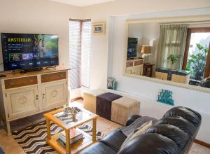 ein Wohnzimmer mit einem Sofa und einem Flachbild-TV in der Unterkunft Stay @ Honeytree in Edenvale