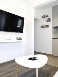 a white coffee table in a living room with a tv at Apartman Misovic in Herceg-Novi