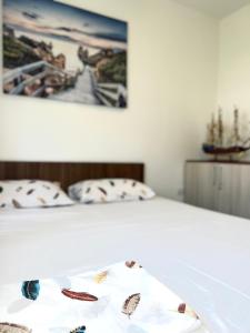 a bed with two pillows and a picture on the wall at Apartman Misovic in Herceg-Novi