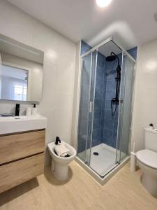 een badkamer met een douche, een toilet en een wastafel bij Apto Olta 3 centro Campello piscina wifi parking in El Campello
