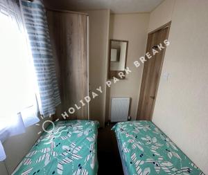 a small bedroom with a bed and a window at Homely 2 bed @ Seal Bay Resort in Selsey +16 photos