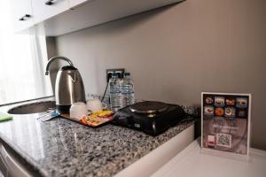 MY HOME IN TRABZON في طرابزون: كاونتر مطبخ مع آلة صنع القهوة وزجاجات الماء