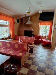 a living room with red chairs and a couch at Penzion Lukáš in Malá Morávka