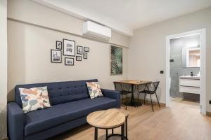 dobohomes - GC21 في مدريد: غرفة معيشة مع أريكة زرقاء وطاولة