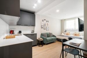 a kitchen and a living room with a couch at dobohomes - GC21 in Madrid