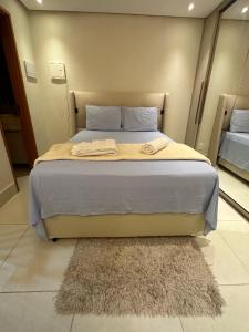 Cama grande en habitación con alfombra en Flat encantador em Bananeiras PB, en Bananeiras