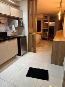 a kitchen with a large white tiled floor at Flat encantador em Bananeiras PB in Bananeiras