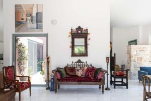 a living room with a couch and a clock on the wall at Kastelokampos Art House in Patra