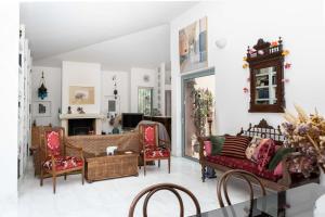sala de estar con sofá, sillas y chimenea en Kastelokampos Art House en Patras