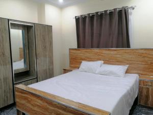 a bedroom with a large bed and a mirror at Navid's Holiday Resort and Hotel, Murree in Ghora Gali