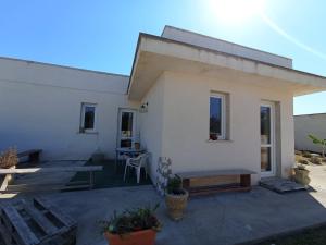 切薩雷奧港的住宿－Stanze Agli Ulivi，白色的房子,配有长凳和桌子