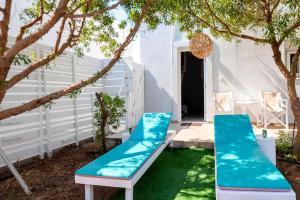 a patio with two blue chairs and a tree at Plimmiri Bay in Plimmiri