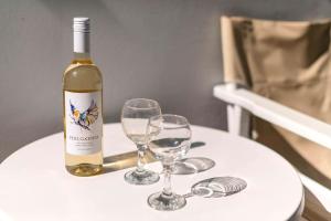 a bottle of wine and two wine glasses on a table at Plimmiri Bay in Plimmiri +15 photos