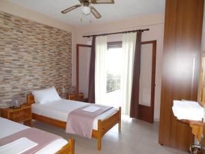 sypialnia z 2 łóżkami i oknem w obiekcie Germanis House w mieście Agios Ioannis Pelio