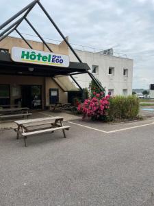 a hotel with a bench in front of a building at Hotel First Eco Dieppe in Dieppe