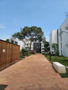 einen Gang vor einem Gebäude mit einem Baum in der Unterkunft Cosy T2 entre terre et mer in Montpellier