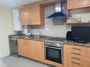 a kitchen with a sink and a stove top oven at Pontevedra Centro adosado in Pontevedra