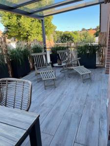 a wooden deck with chairs and tables on it at Excl. Maisonette Ferienwohnung in Coesfeld