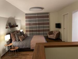a bedroom with a bed and a couch and a chair at Excl. Maisonette Ferienwohnung in Coesfeld