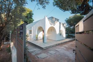 a white house with a gate in a yard at Sea Zen Guesthouse in Rafina