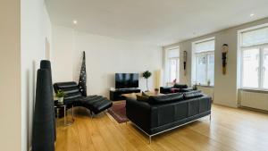 - un salon avec un canapé et des fauteuils en cuir noir dans l'établissement ApartmentInCopenhagen Apartment 1555, à Copenhague