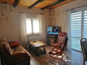 - un salon avec un canapé, une table et une télévision dans l'établissement Dom na wzgórzu, à Kiczora