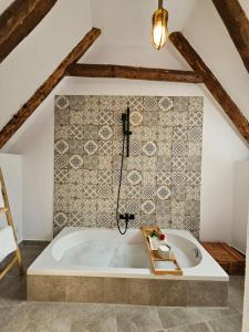baño con bañera y pared de azulejos en The Hut Retreat, en Fîntînele