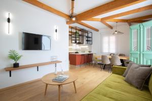 a living room with a green couch and a table at Angestrale Wood in Lefkada Town