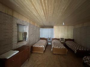 ein kleines Zimmer mit 2 Betten und einem Spiegel in der Unterkunft Shio's Stonehouse in Tusheti in Tusheti