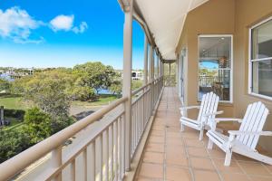 a balcony with two chairs and a view of the ocean at Spinnaker Quays in Mooloolaba