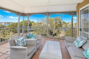 un porche cubierto con 2 sofás y una mesa en Spinnaker Quays en Mooloolaba