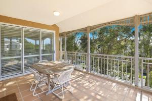a screened in porch with a table and chairs at Spinnaker Quays in Mooloolaba