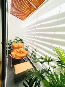 a balcony with an orange chair and plants at Sol Valley - Hideaway Station in Blao Srê