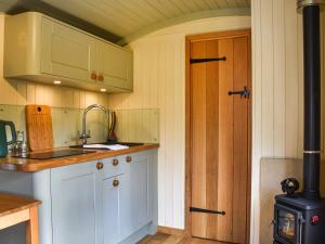 a kitchen with white cabinets and a sink at Bechan Brook Hut in Bettws Cedewain