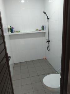 biała łazienka z toaletą i prysznicem w obiekcie Adinda Syariah B 09 Paseban ke 3 