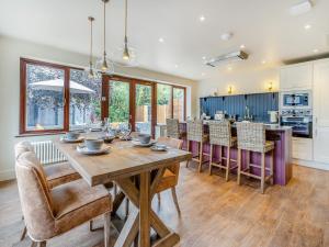 a kitchen and dining room with a wooden table and chairs at Dant Y Llew - Uk42790 in Bow Street