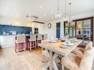 a kitchen and dining room with a wooden table and chairs at Dant Y Llew - Uk42790 in Bow Street