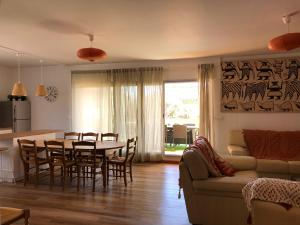a kitchen and living room with a table and a couch at VILLA TAPÔA - Maison au coeur de Marseillan in Marseillan