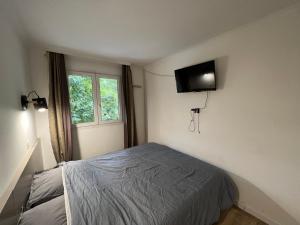 1 dormitorio con 1 cama y TV en la pared en Appartement T2 / La Défense en Courbevoie