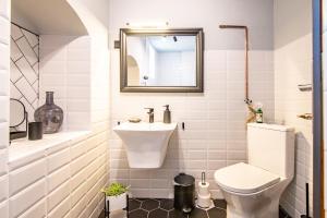 a white bathroom with a toilet and a sink at Somlói Vándor Lodge in Somlóvásárhely