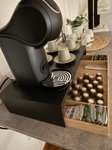 a black coffee machine on a table with cupcakes at Two Rooms Chiaia 37 in Naples